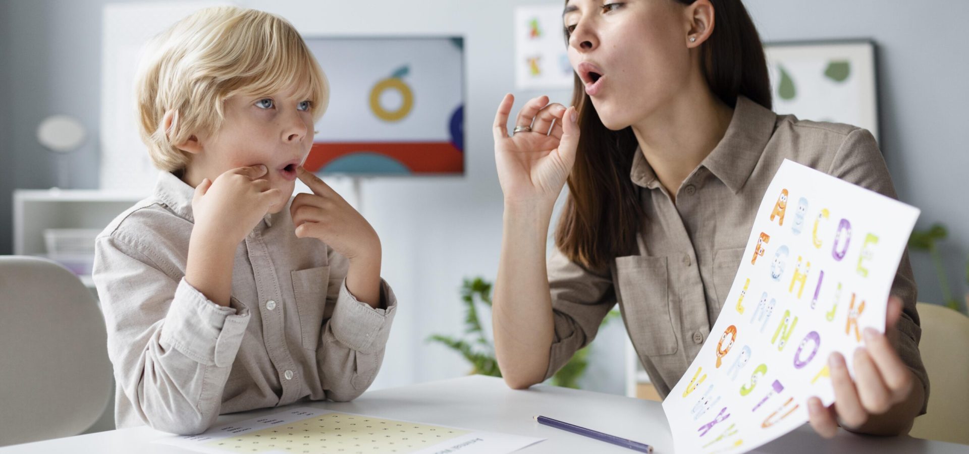 woman-doing-speech-therapy-with-little-blonde-boy